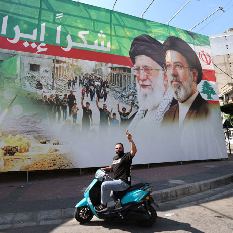 A man flashes the victory sign in front of a billboard depicting the late Iranian leader Ayatollah Ali Khamenei and Iranian Supreme Leader Ayatollah Mojtaba Khamenei in Beirut, Lebanon, on June 15, 2026.