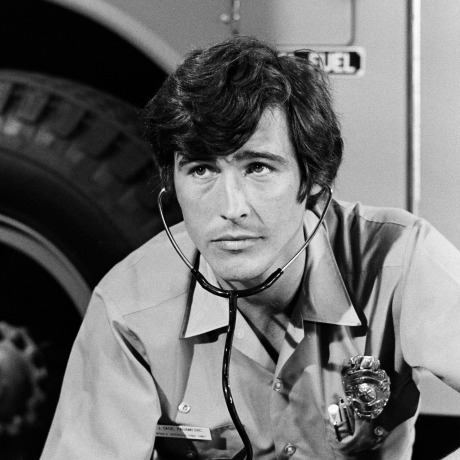 A black and white photo of actor Randolph Mantooth in character as a paramedic.