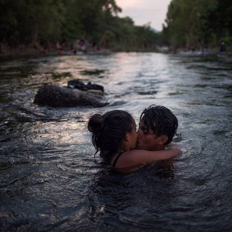 Image: Couple kiss in Rio Novillero as caravan from Central America en route to U.S. stops in San Pedro Tapanatepec, Mexico