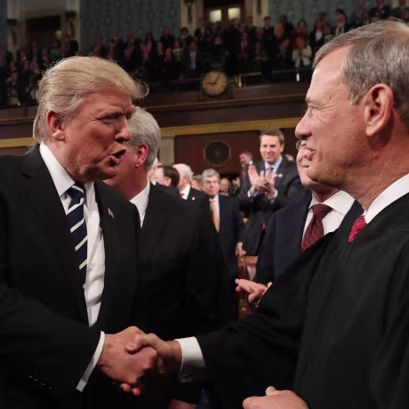 Image: President Donald Trump shakes hands with US Supreme Court Chief Justice John Roberts