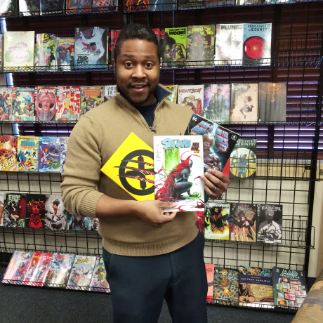 Eric Childs hold comic books inside Mind's Eye Comics store in Burnsville, Minn.