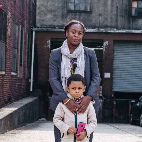 Melissa Miles with son Kiluan in front of the plastics factory in Newark's Ironbound neighborhood.