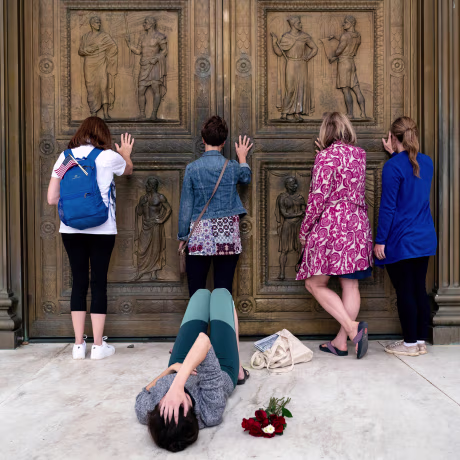Image: Conservative women who support Judge Amy Coney Barrett's nomination to the Supreme Court, pray while touching the doors of the Supreme Court in Washington as Jacquelyn Booth lays on the ground mourning the death of Justice Ruth Bader Ginsburg on Sa