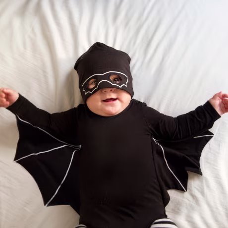 Baby boy dressed as a bat and wearing a mask