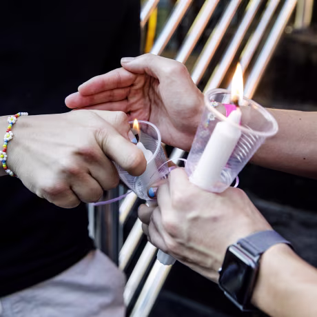People light candles during a vigil commemorating Julio Ramirez on June 8, 2022, who died mysteriously after leavig a gay bar in April.