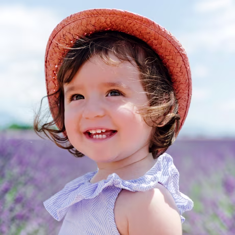 Happy toddler girl in purple lavender fields in the summer