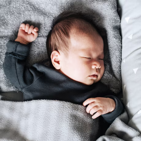 Asian newborn baby sleeping soundly in the crib at home
