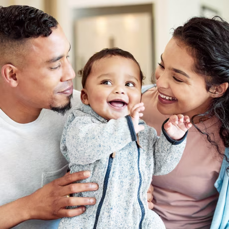 Shot of a young family bonding with their baby at home