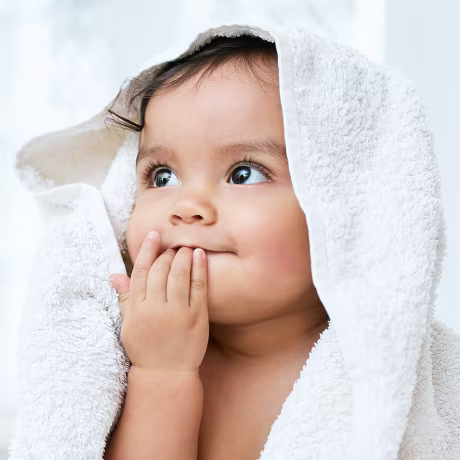 Shot of an adorable baby covered in a towel after bath time