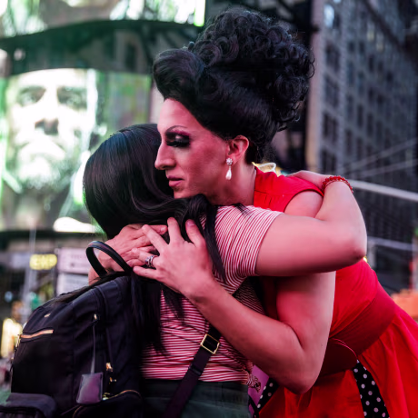 Two people hug in Times Square during a vigil