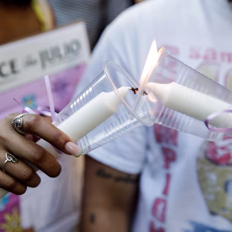 People light candles during a vigil commemorating Julio Ramirez on June 8, 2022.
