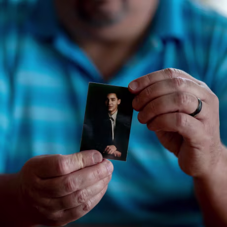 Hector Adames holds a small photo of Joshua Adames.
