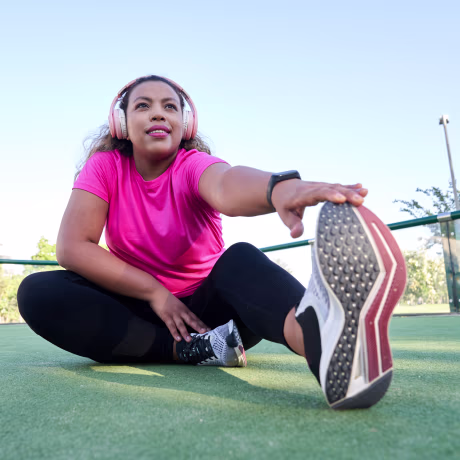Latin woman with large build stretching after jogging