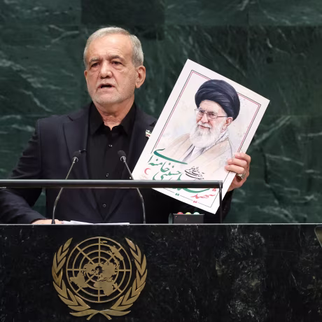 Iran's President Masoud Pezeshkian holds a picture of Ali Khamenei at the United Nations General Assembly