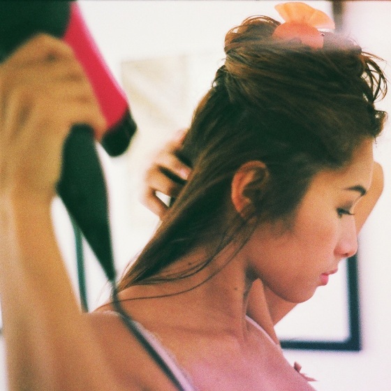 Young Woman Blow Drying Hair At Home