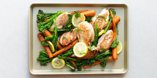 A dish of chicken, broccolini and carrots