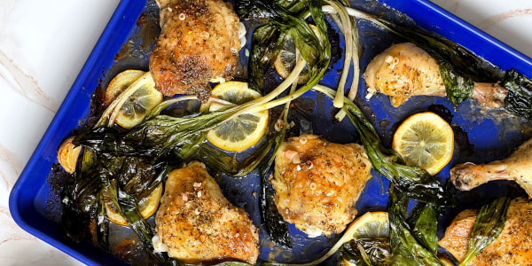 Chicken on plate with ramps, lemon and crushed garlic