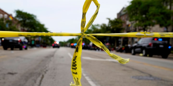 Police tape hangs at the corner of Central Avenue and Green Bay Rd., in Highland Park, Ill., after a mass shooting on Monday.