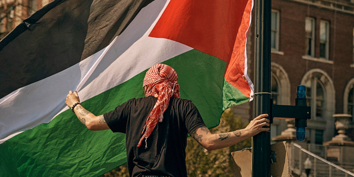 A protester places a Palestinian flag at a pro-Palestinian encampment at Columbia University, in New York, Sunday, April 28, 2024.