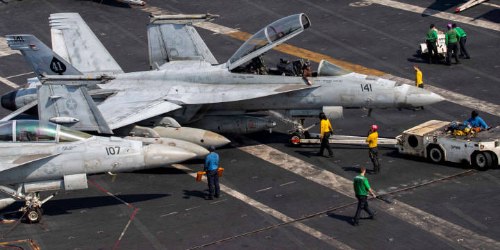 US sailors taxiing an F/A-18F Super Hornet, attached to Strike Fighter Squadron (VFA) 41, on the flight deck aboard Nimitz-class aircraft carrier USS Abraham Lincoln.