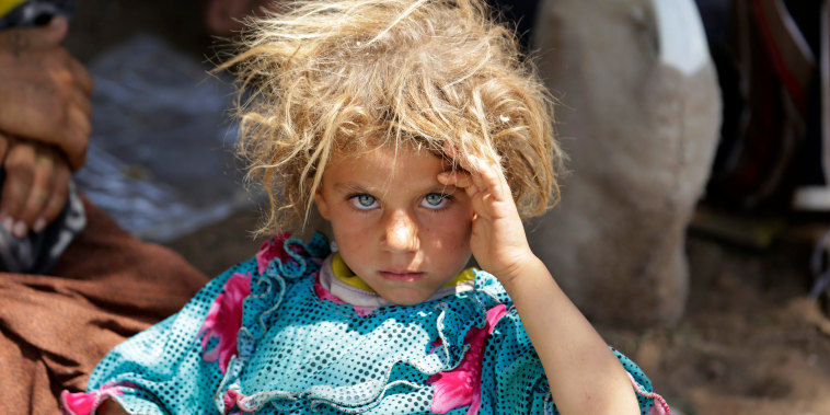 A girl from the minority Yazidi sect, fleeing the violence in the Iraqi town of Sinjar, rests at the Iraqi-Syrian border crossing in Fishkhabour