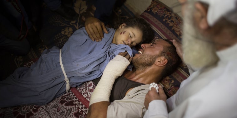 The injured father of 2-year-old Rahaf Hassan cries as he holds her body during the funeral, Oct. 11, 2015, after she and her 30-year-old pregnant mother, Noor Hassan, were killed in Israeli air strike earlier in the day. (Photo by Khalil Hamra/AP)