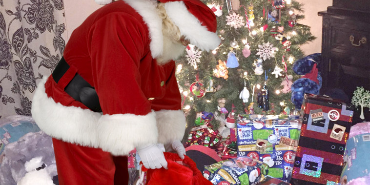 Santa putting presents under the tree.