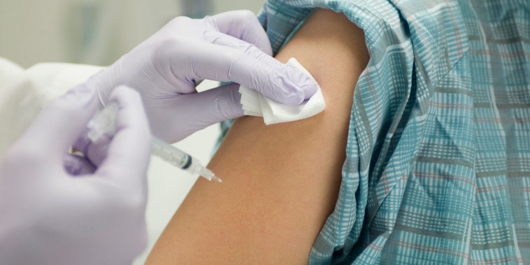 Doctor placing gauze on patient's arm after administering a shot