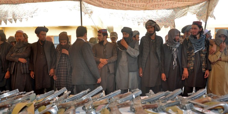 Image: Members of Islamic State hand over their weapons to the Afghan forces during a ceremony in Jawzjan province