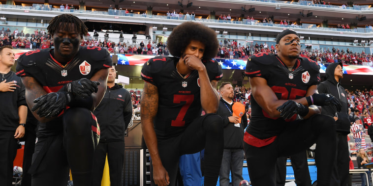 Image: Eli Harold, from left, Colin Kaepernick, and Eric Reid of the San Francisco 49ers kneel in protest during the national anthem