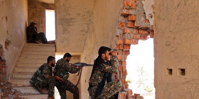 Kurdish People's Protection Units (YPG) fighters take up positions inside a damaged building in al-Vilat al-Homor neighborhood in Hasaka city, as they monitor the movements of Islamic State fighters  stationed in Ghwayran neighborhood in Hasaka city, Syria, on July 22, 2015.