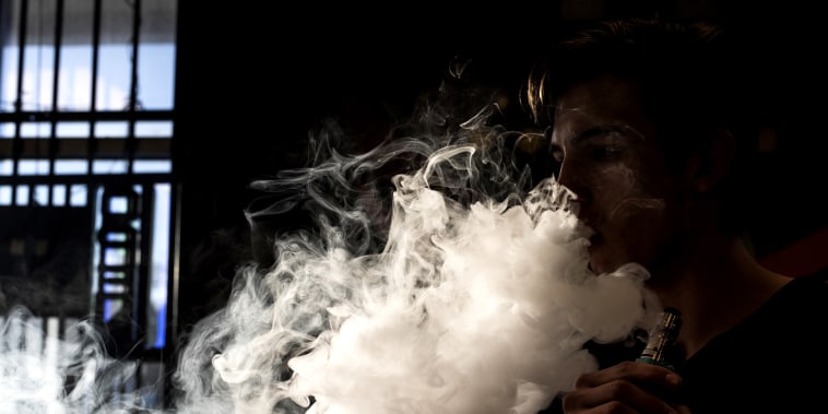 Image: A person smokes an e-cigarette in Albuquerque, N.M., in 2016.