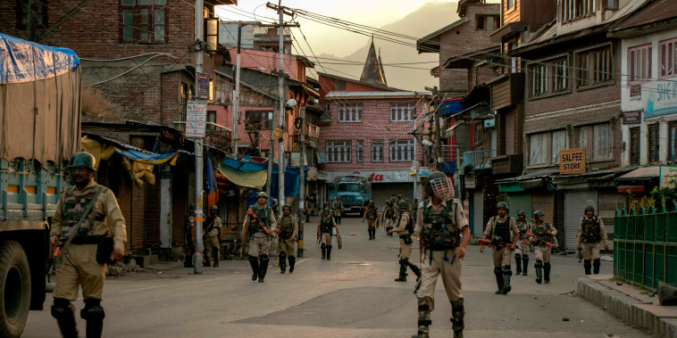 Image: Indian security personnel walk on a street in Srinagar on Aug. 9, 2019.