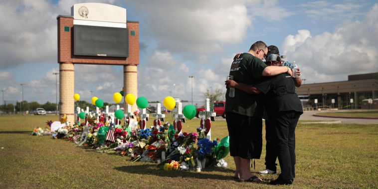 Image: Mourners pray at a memorial in front of Santa Fe High School