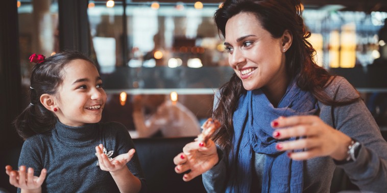 Image: Mother with little daughter eating dinner in restaurant