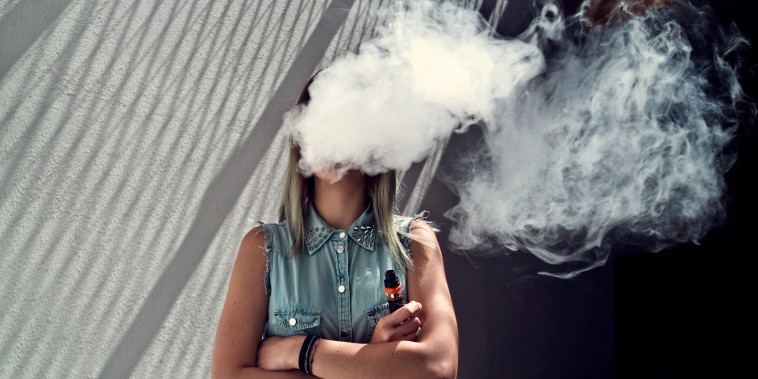 Image: Young woman with her head in a cloud of vapor smoke