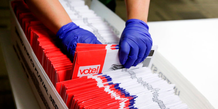 Image: A poll worker sorts vote-by-mail ballots in Renton, Wash., on March 10, 2020.