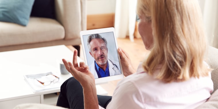 Mature Woman Having Online Consultation With Doctor At Home On Digital Tablet