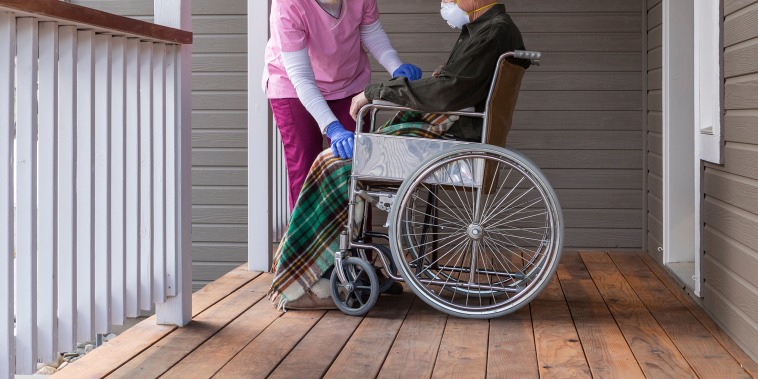 Image: Caretaker, nurse, man in wheelchair on porch, stock