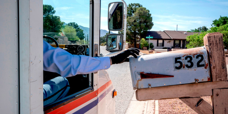 Image: A USPS mail carrier delivers mail in El Paso, Texas, on April 30, 2020.