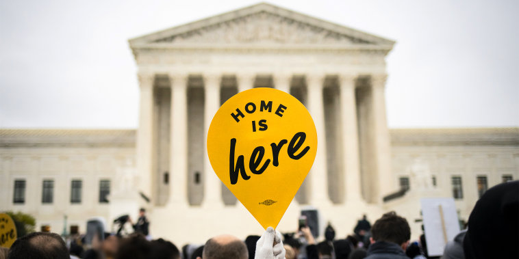 A demonstrator holds a "Home Is Here" sign during a rally supporting the Deferred Action for Childhood Arrivals program (DACA) outside of the Supreme Court on Nov. 12, 2019.