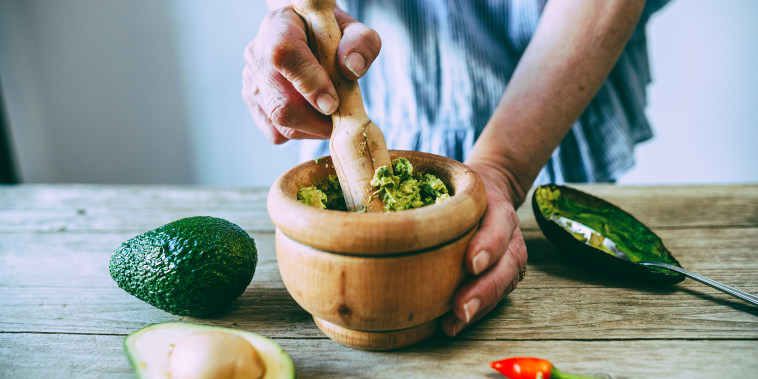 Close-up of hands making homemade guacamole