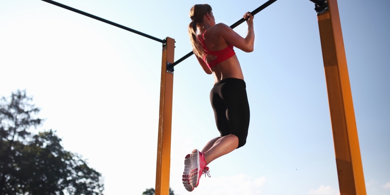Girl training on chin-up bar outdoor