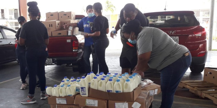 Volunteers help distribute milk in Loiza, Puerto Rico.