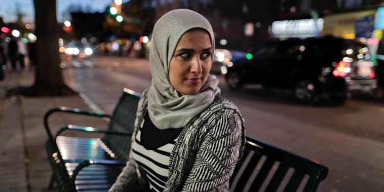 IMage: Enas Almadhwahi, an immigration outreach organizer for the Arab American Association of New York, sits for a photo along Fifth Avenue in the Bay Ridge neighborhood of Brooklyn.