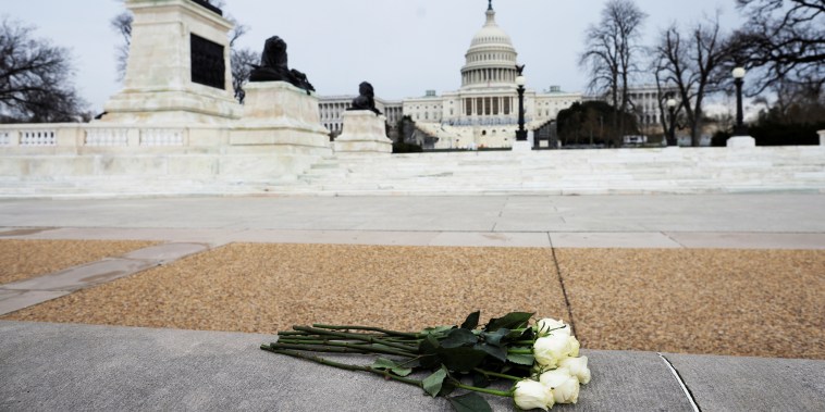 Image: Azhenedt Sanabria holds flowers as she pays her respects to late Capitol Police Officer Brian Sicknick