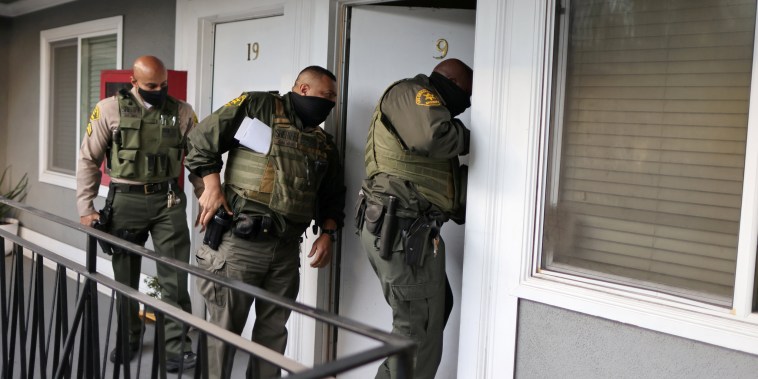 Image: Los Angeles Sheriff's Deputies open the door of an empty apartment to carry out an eviction order, as the spread of the coronavirus disease (COVID-19) continues, in Los Angeles