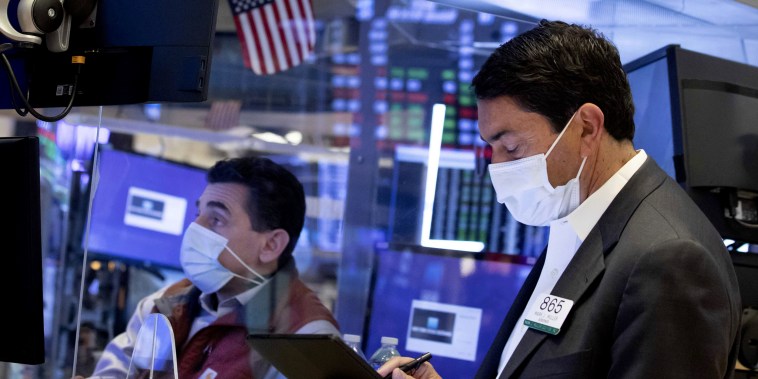 Image: Trader Mark Muller, right, and specialist Peter Mazza work on the trading floor of the New York Stock Exchange on March 24, 2021.