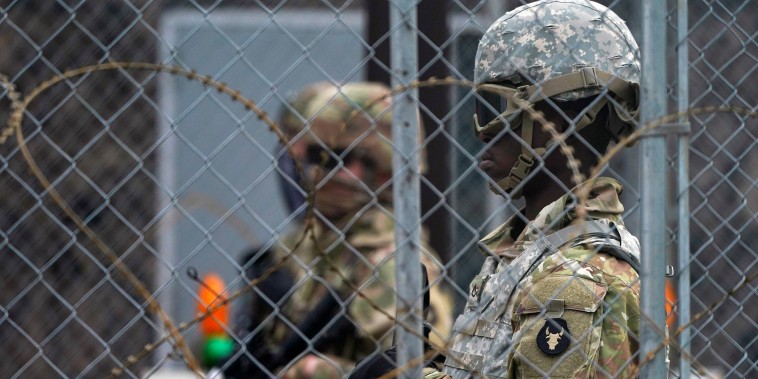 Image: National Guard members are seen through fencing and wire near the Minneapolis Police 3rd Precinct in Minneapolis