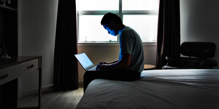 Man sitting in bed with a laptop